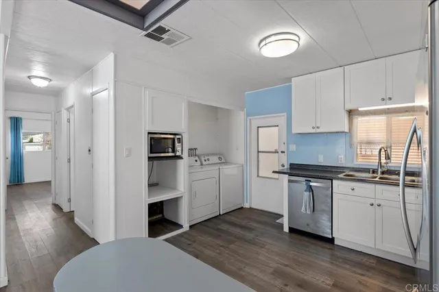 a kitchen with white cabinets and stainless steel appliances
