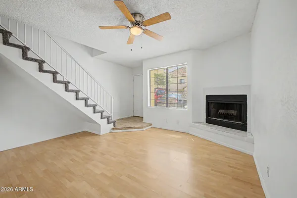 a view of an empty room with fireplace and a window