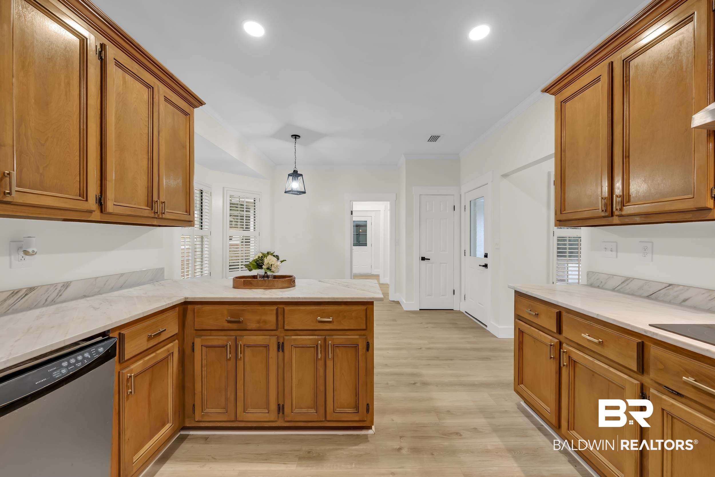 4924 Brooke Court Mobile, AL 36618 - Photo 16 of 34 Kitchen with brown cabinets, stainless steel dishwasher, a peninsula, light wood-type flooring, and hanging light fixtures