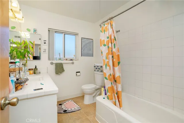 a bathroom with a sink a toilet and shower curtain