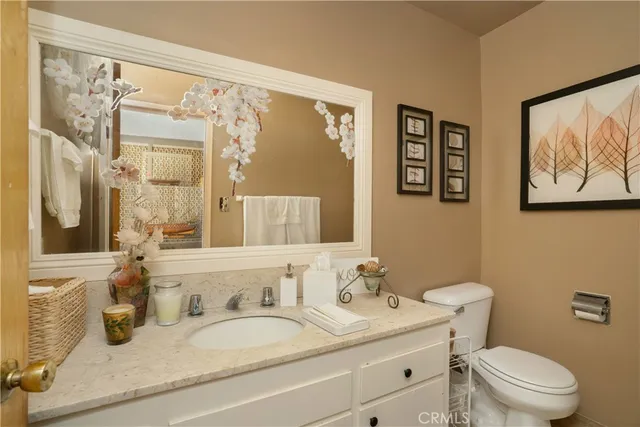 a bathroom with a granite countertop sink mirror vanity and toilet