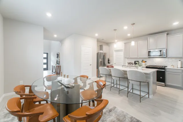 a kitchen with a dining table chairs sink and a stove