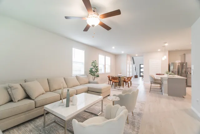 a living room with furniture and a view of kitchen