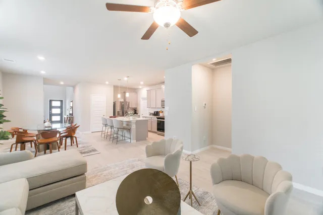 a living room with furniture a dining table and a chandelier
