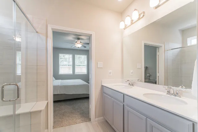 a en suite bathroom with a double vanity sink a mirror and a shower
