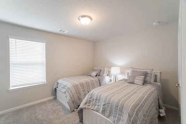 a bedroom with two beds and a window