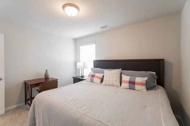 a bedroom with a bed and a night stand