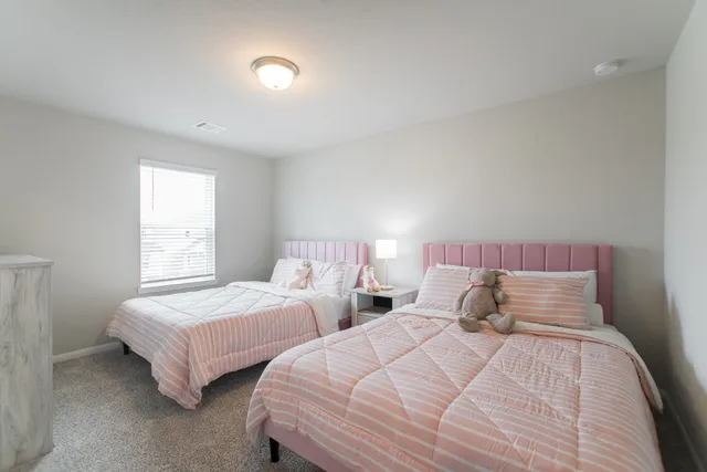 a bedroom with two bed and a lamp