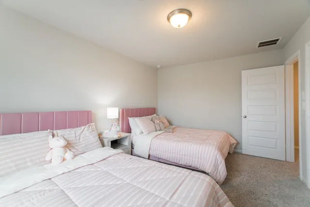 a bedroom with two bed and a night stand