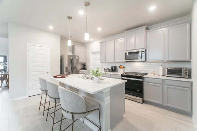 a kitchen with kitchen island granite countertop white cabinets and stainless steel appliances