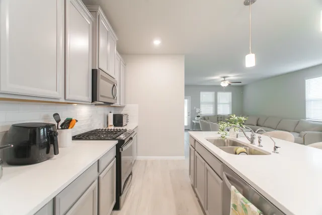a kitchen with a sink a stove and cabinets