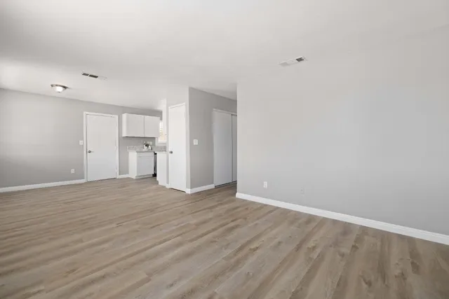 a view of empty room with wooden floor