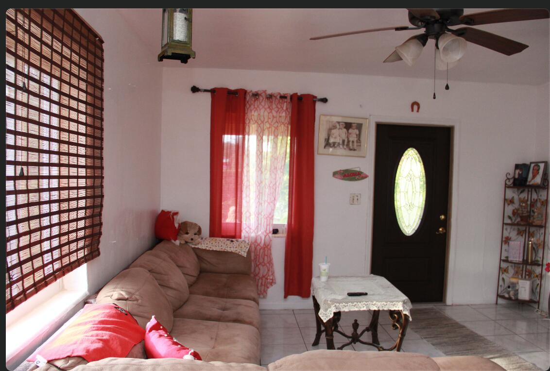 1402 South C Street Lake Worth Beach, FL 33460 - Photo 20 of 27 a living room with furniture a large window and a chandelier