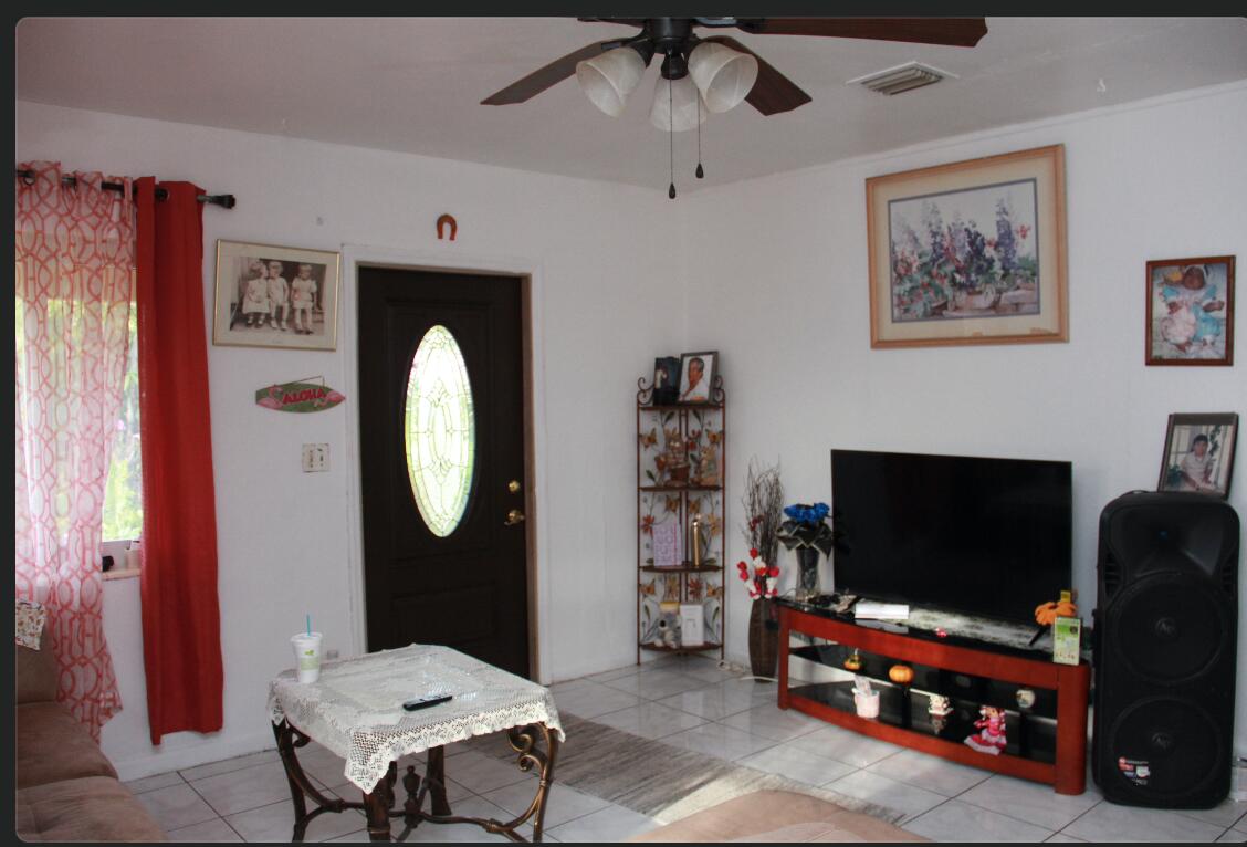 1402 South C Street Lake Worth Beach, FL 33460 - Photo 21 of 27 a living room with furniture a flat screen tv and a fireplace