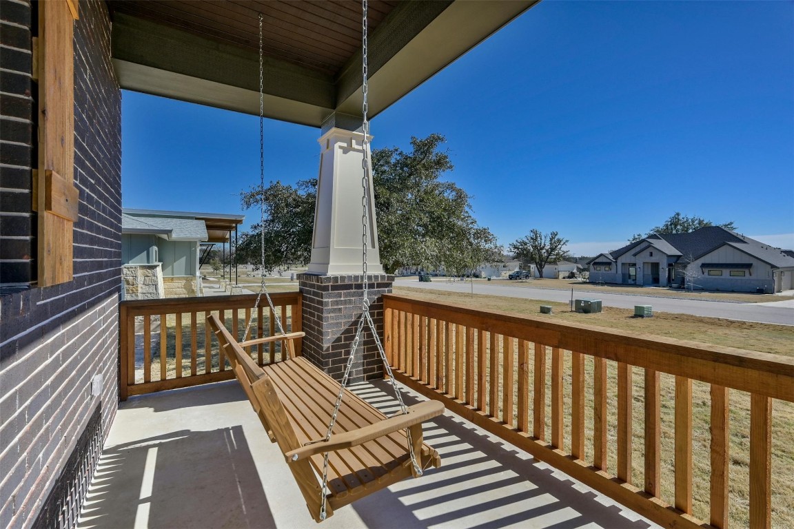 Front porch has porch swing, overlooking homes all on 1+ acres.