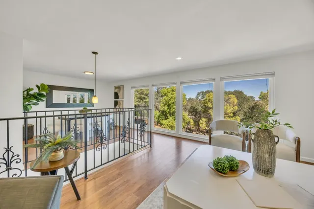 a dining room with chandelier and wooden floor