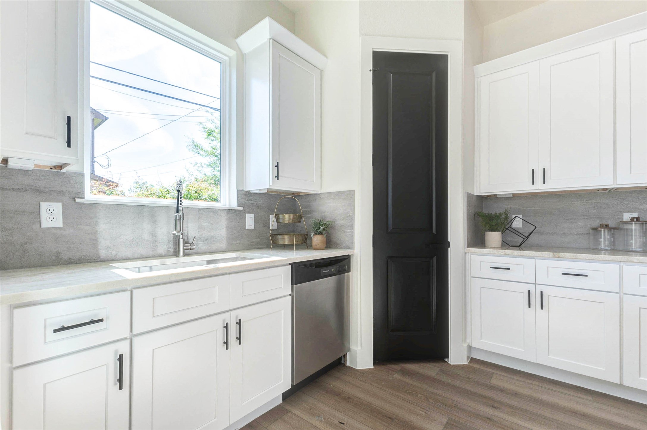 7115 England Street, Unit C Houston, TX 77021 - Photo 3 of 19 The functional kitchen design includes a deep basin sink, integrated dishwasher, and a contrasting black pantry door.