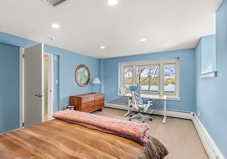 a bedroom with a bed and table with chair