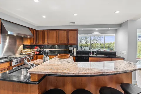 a kitchen with stainless steel appliances granite countertop a sink and a white cabinets