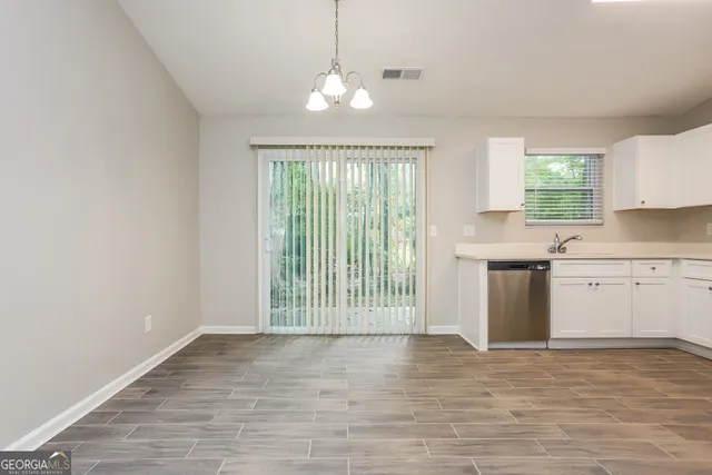 a view of a kitchen with wooden floor and a window
