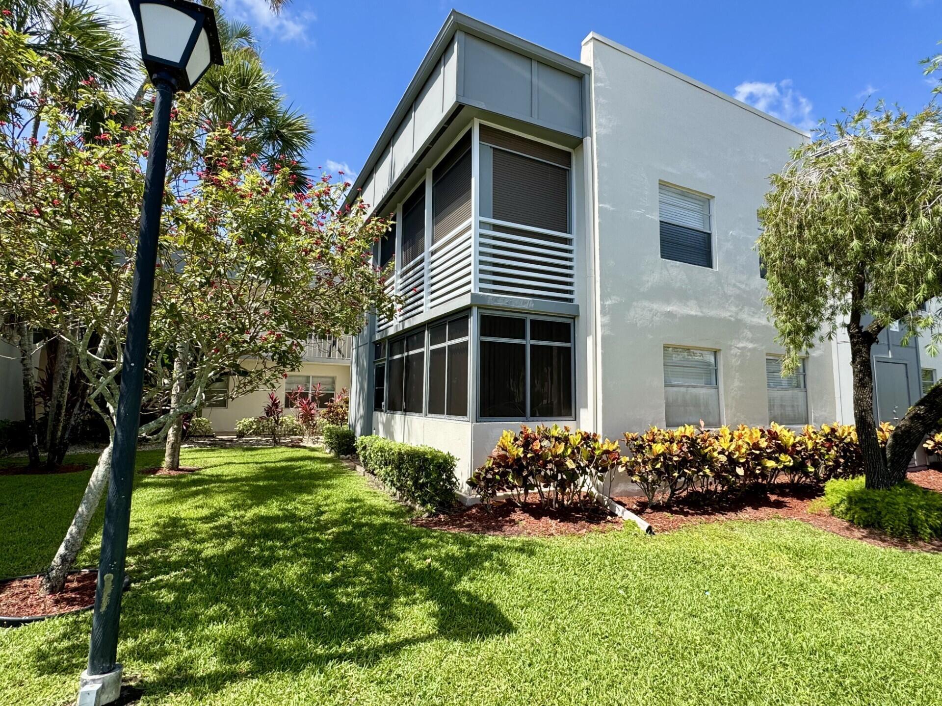 541 Normandy L Delray Beach, FL 33484 - Photo 1 of 55 a front view of a house with a garden