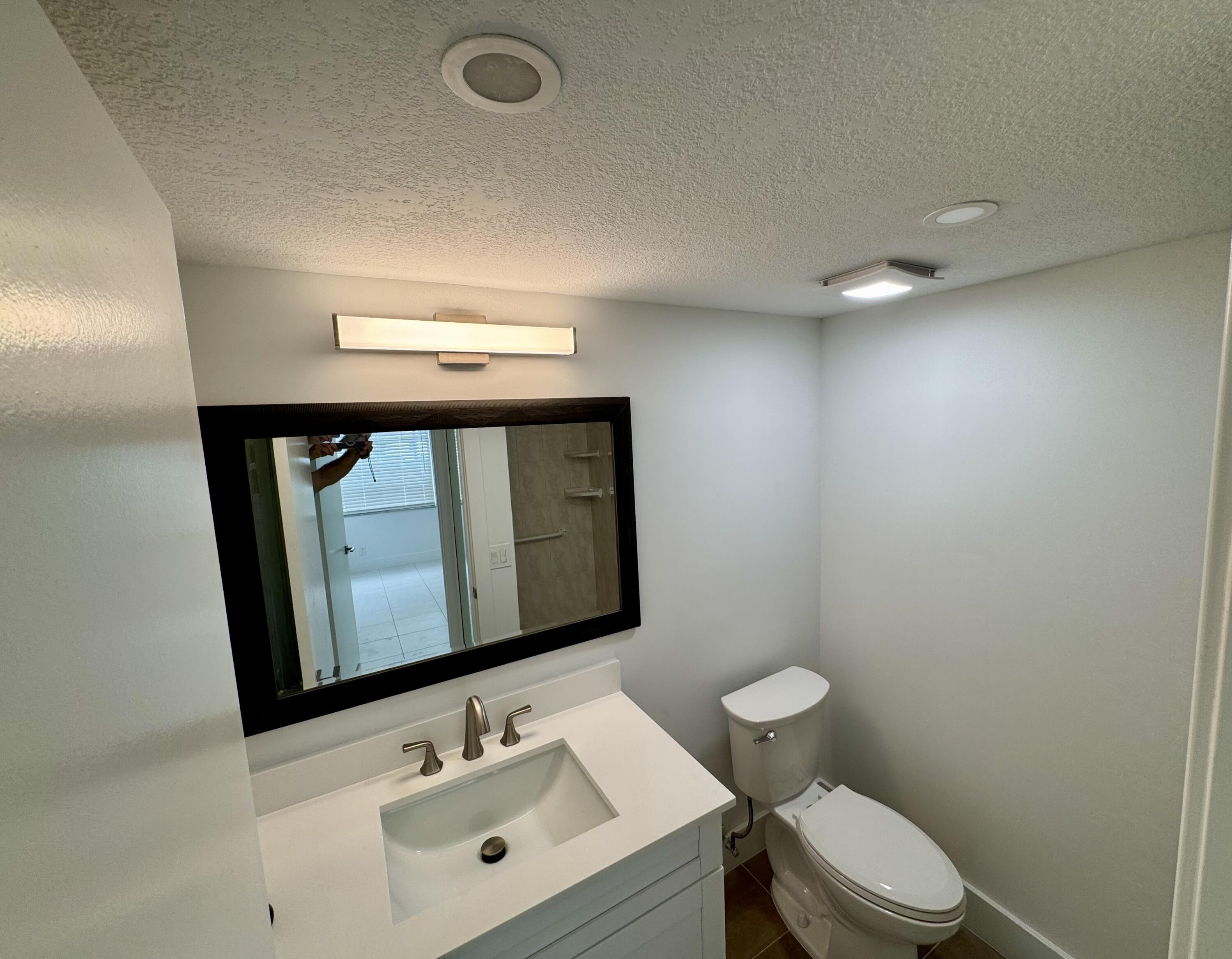 541 Normandy L Delray Beach, FL 33484 - Photo 13 of 55 a bathroom with a sink mirror and toilet
