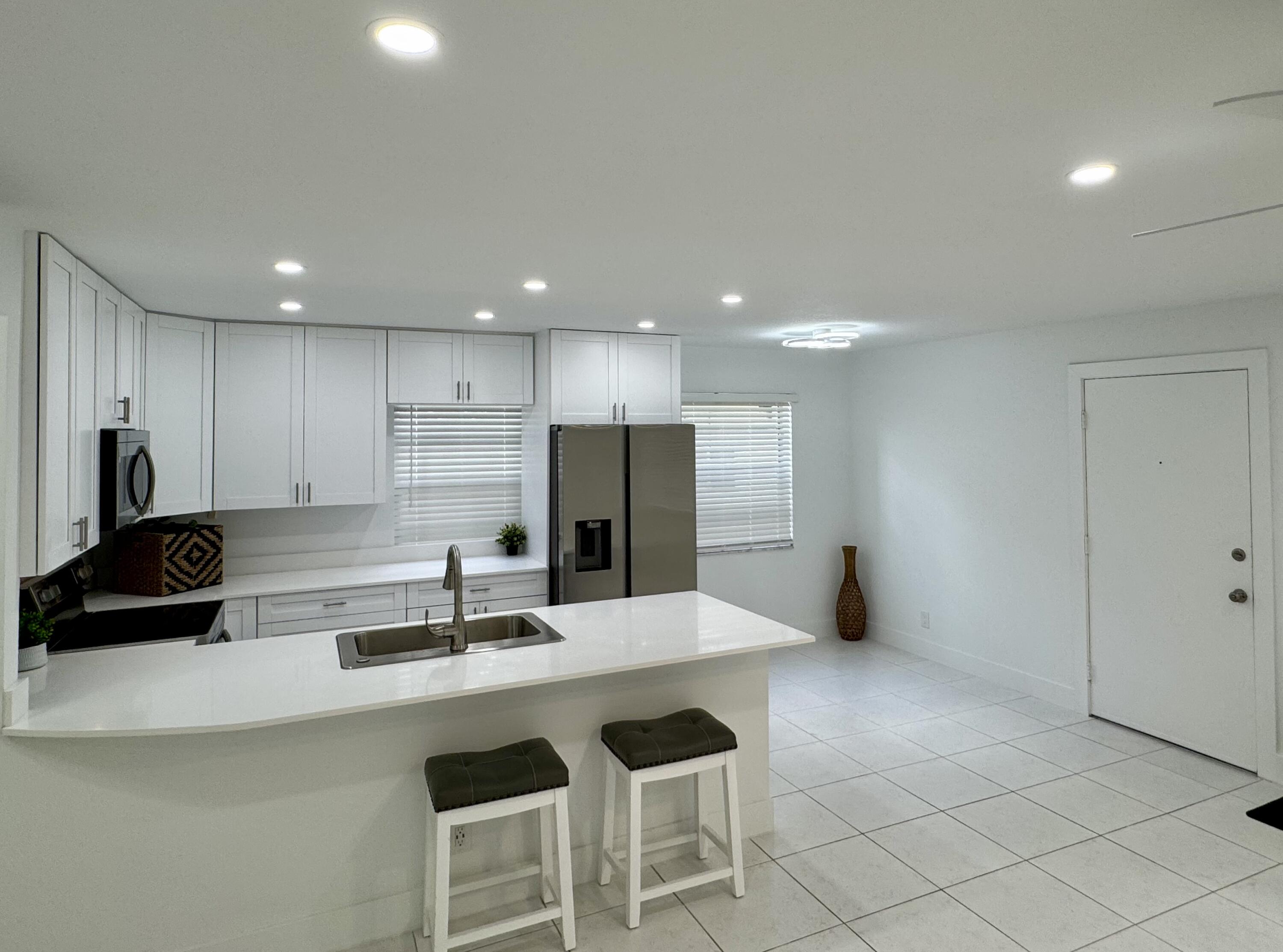 541 Normandy L Delray Beach, FL 33484 - Photo 2 of 55 a kitchen with stainless steel appliances kitchen island granite countertop a sink and cabinets