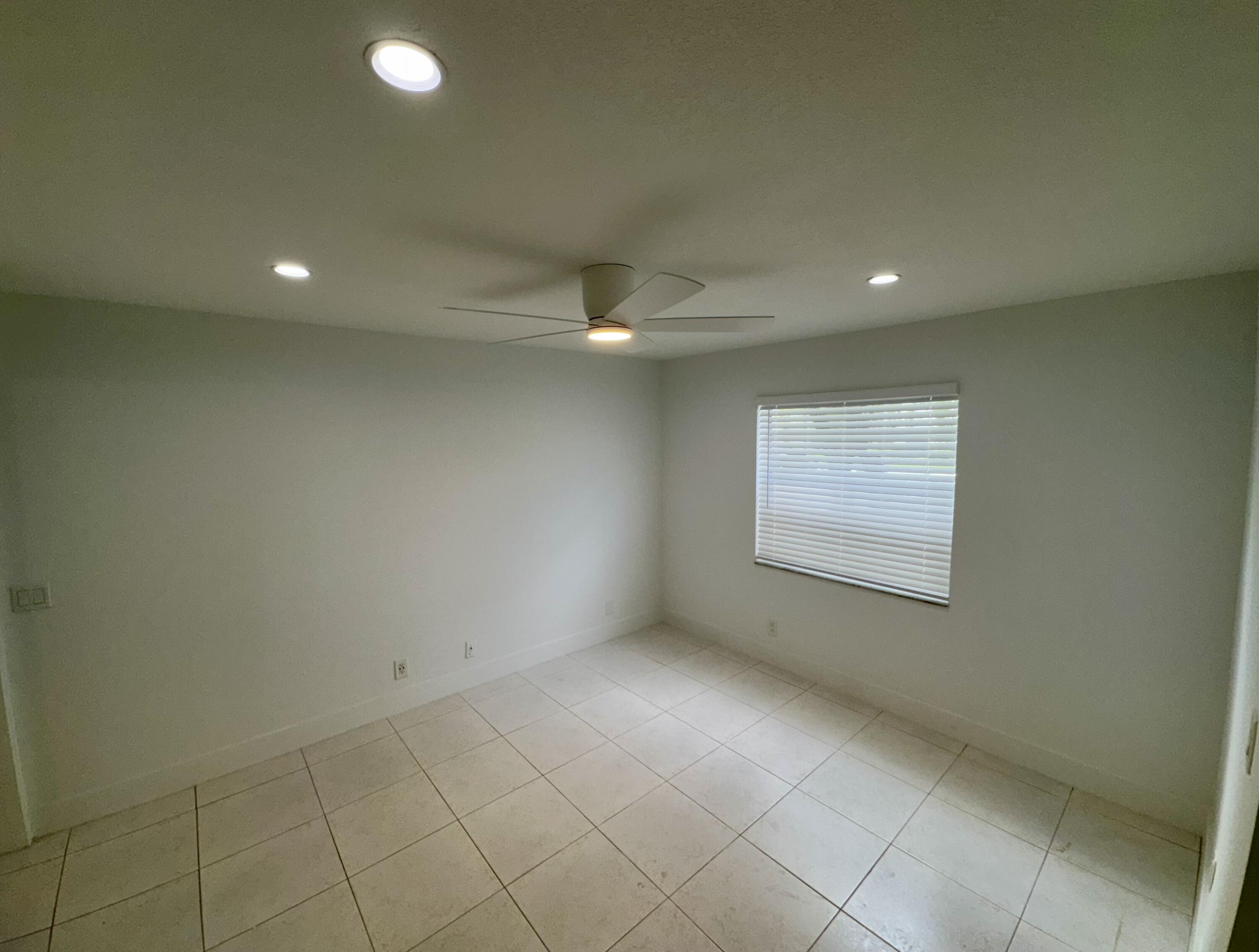 541 Normandy L Delray Beach, FL 33484 - Photo 23 of 55 an empty room with a ceiling fan and window
