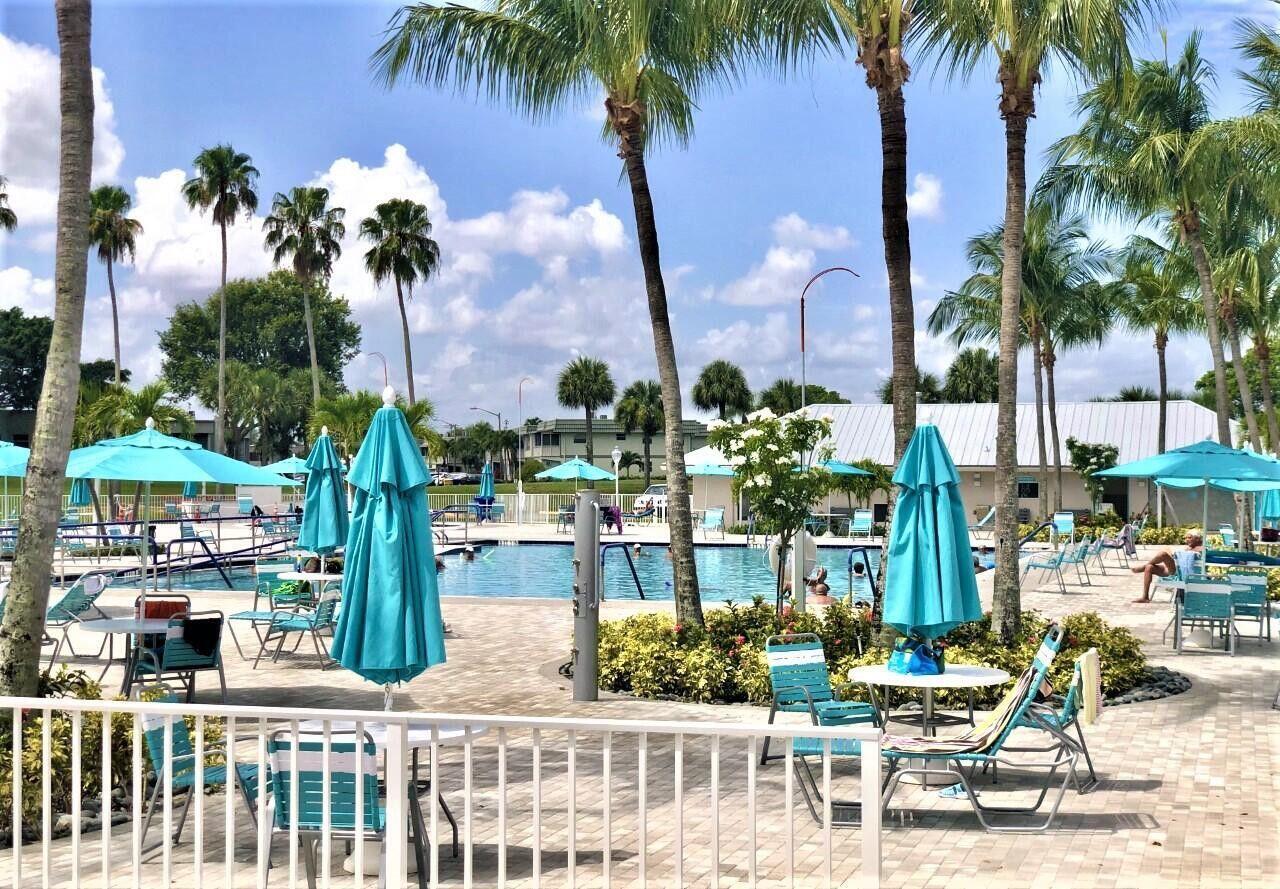 541 Normandy L Delray Beach, FL 33484 - Photo 24 of 55 a front view of multi story residential apartment building with yard and outdoor seating
