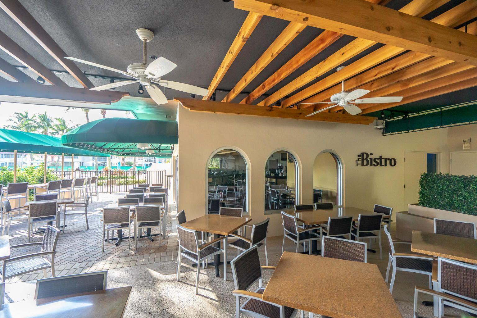 541 Normandy L Delray Beach, FL 33484 - Photo 29 of 55 a room with lots of tables a large window and chairs