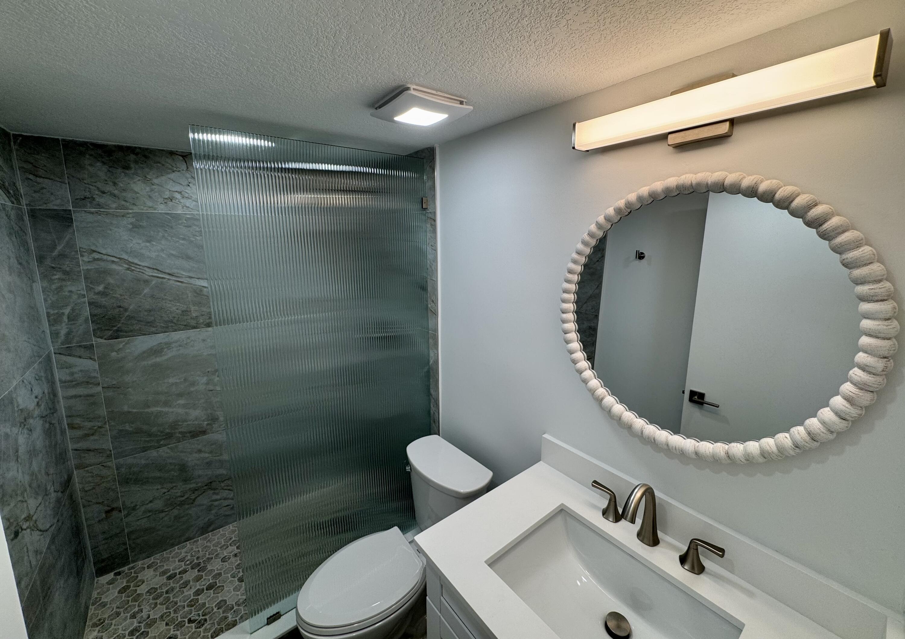 541 Normandy L Delray Beach, FL 33484 - Photo 8 of 55 a bathroom with a toilet sink and mirror