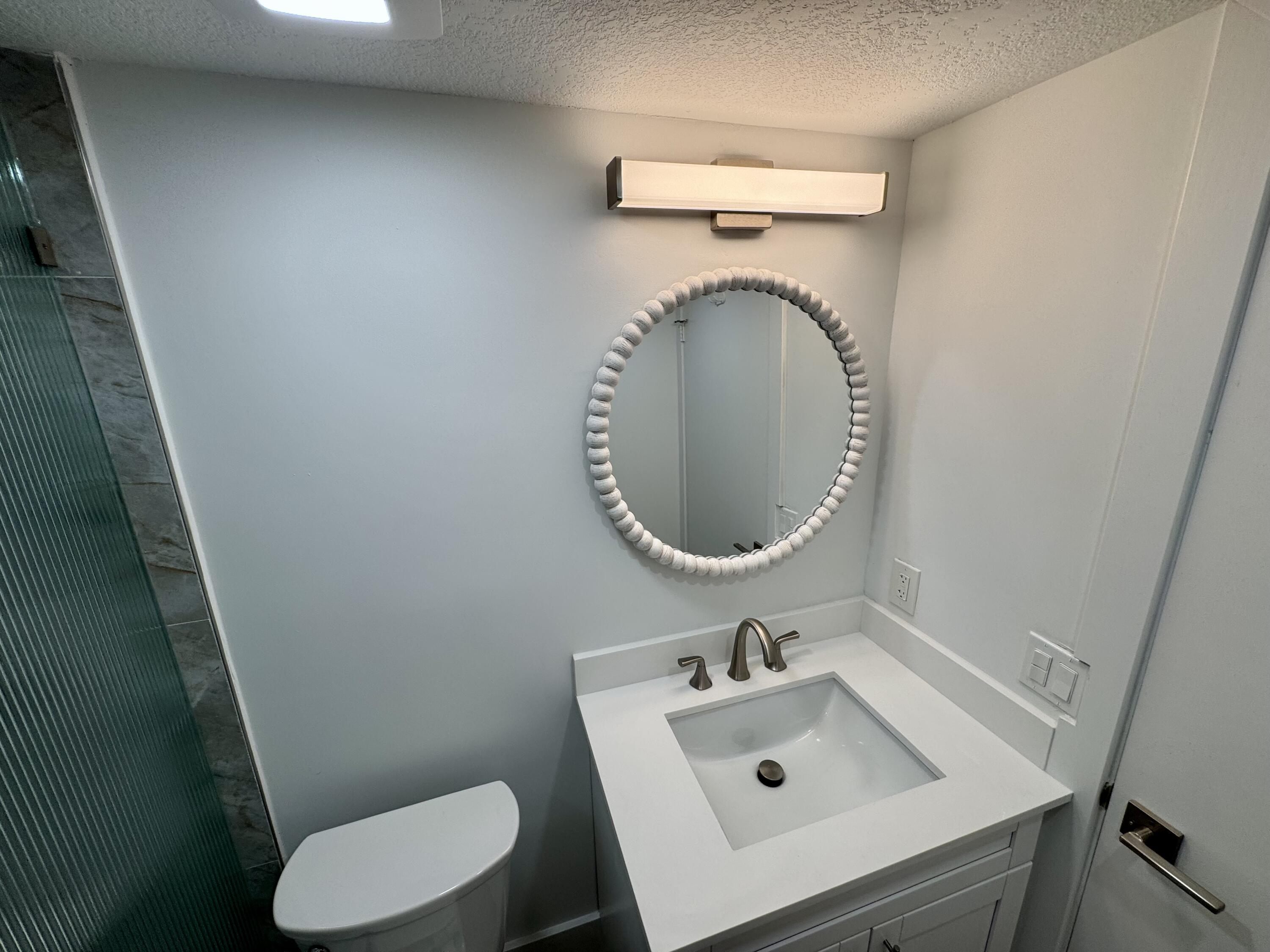 541 Normandy L Delray Beach, FL 33484 - Photo 9 of 55 a bathroom with a sink toilet and a mirror