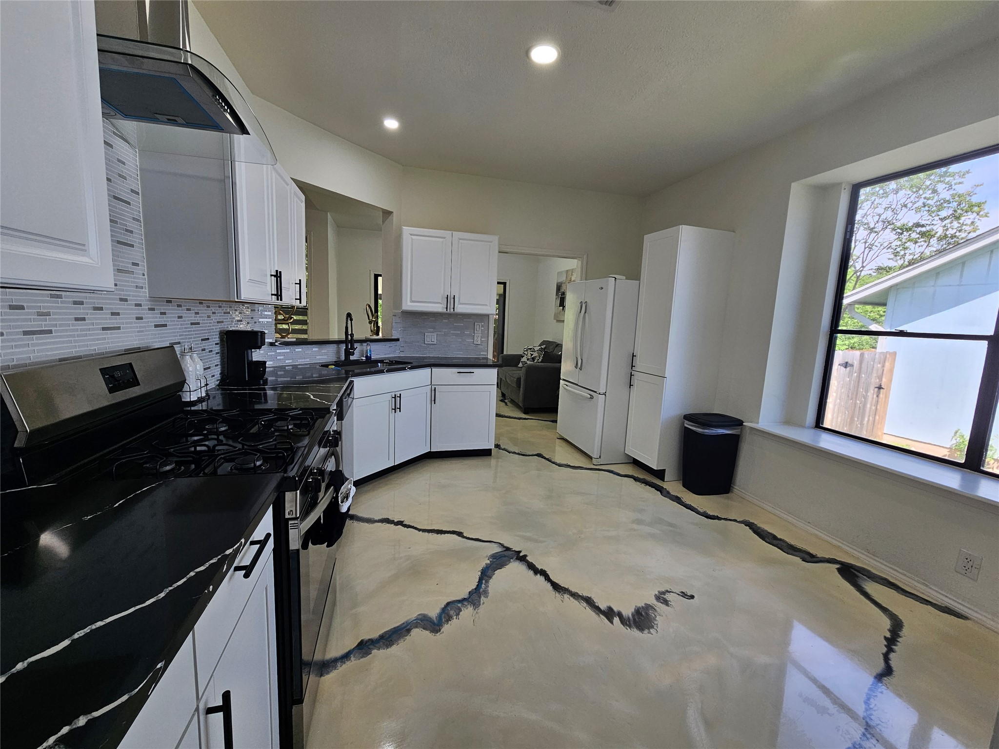 11806 Prairie Hen Lane Austin, TX 78758 - Photo 4 of 16 a kitchen with a stove a sink and a refrigerator