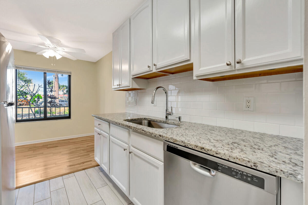 150 Pineview Road, Unit B2 Jupiter, FL 33469 - Photo 7 of 13 a kitchen with stainless steel appliances granite countertop a sink and dishwasher