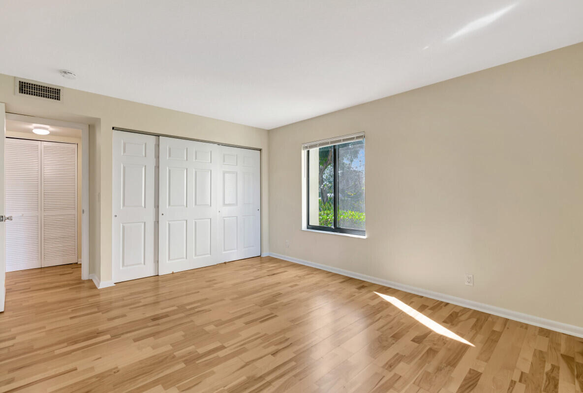 150 Pineview Road, Unit B2 Jupiter, FL 33469 - Photo 8 of 13 a view of an empty room with wooden floor and a window