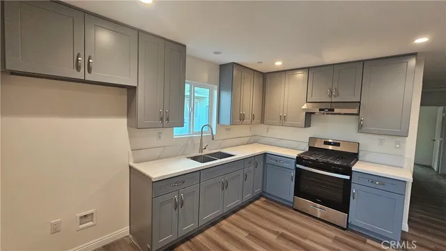 a kitchen with a sink stove and cabinets