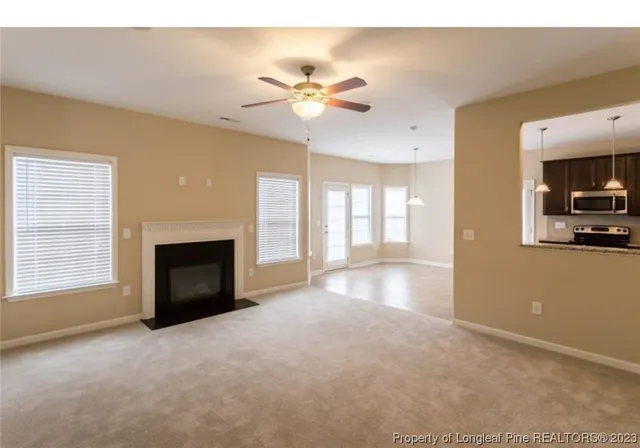 a view of empty room with a fireplace and fan