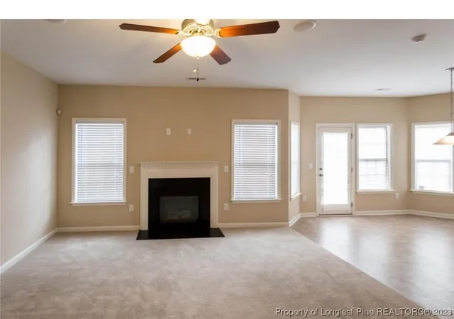 a view of a livingroom with a fireplace and window