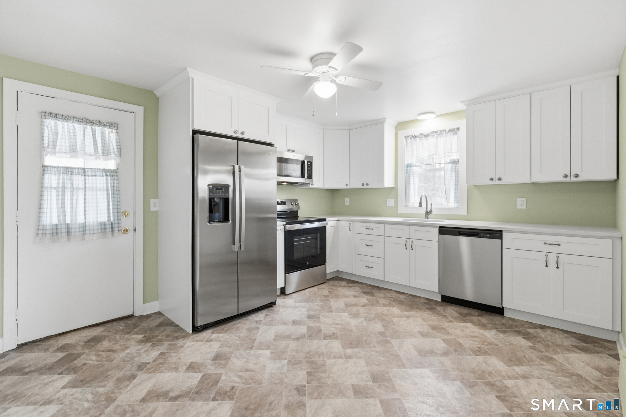 217 East Waterbury Road Naugatuck, CT 06770 - Photo 3 of 38 a kitchen with white cabinets stainless steel appliances and a window