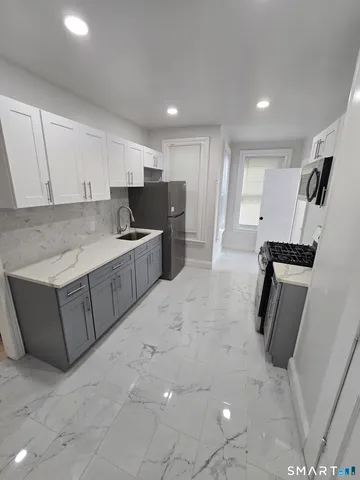 a kitchen with kitchen island a sink appliances and cabinets