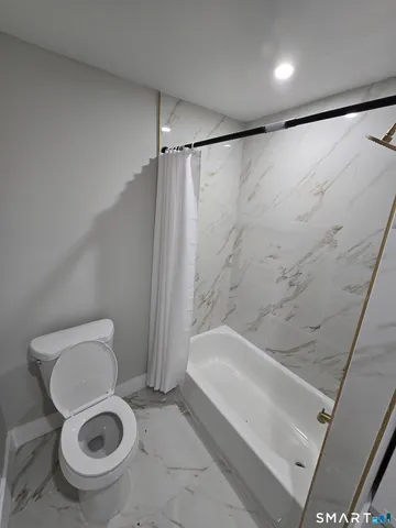 a bathroom with a toilet and a shower
