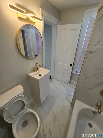 a bathroom with a toilet sink and mirror