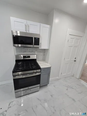 a stove top oven sitting inside of a kitchen