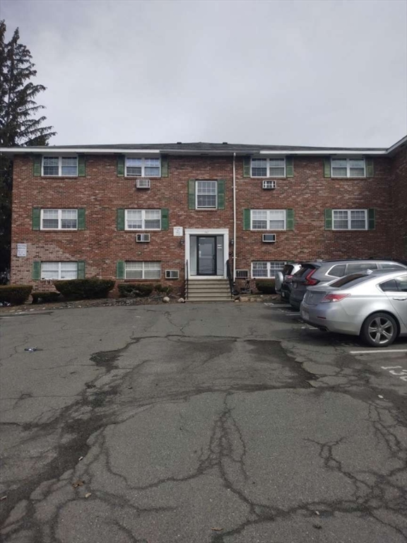 a front view of a building with parking space