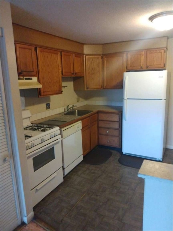 367 Hildreth Street, Unit 33 Lowell, MA 01850 - Photo 2 of 6 a kitchen with a stove sink and cabinets