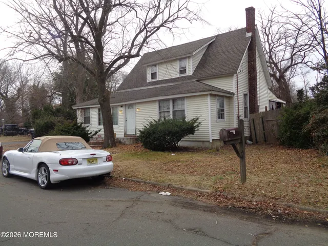 a white house covered with tall trees
