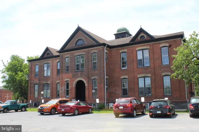 a front view of a house with cars parked