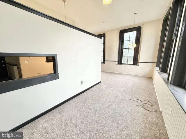 a view of a big room with windows and stairs