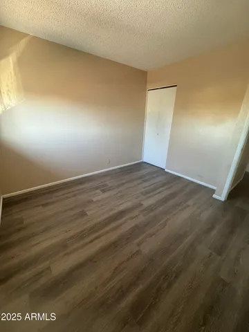 an empty room with wooden floor and windows in it
