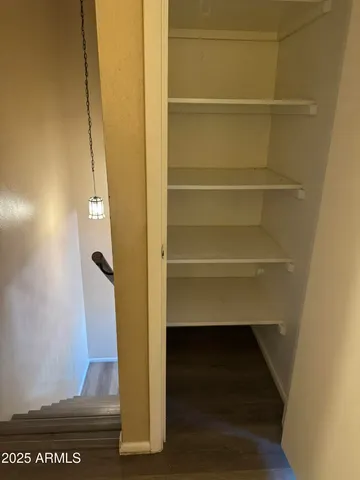 a view of walk in closet with empty racks